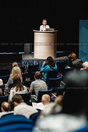 Female speaker giving a talk on corporate business conference. Unrecognizable people in audience at conference hall. Business and Entrepreneurship event. Стоковое фото, фотограф Matej Kastelic / Фотобанк Лори