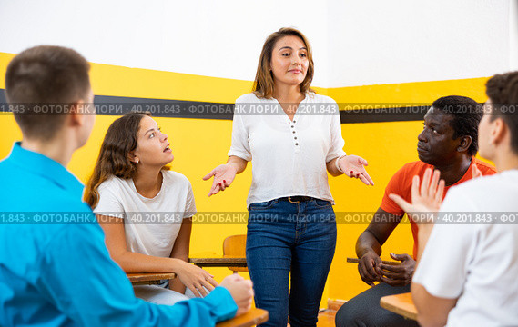 Female student discussing with groupmates sitting in circle in auditorium during classes. Стоковое фото, фотограф Яков Филимонов / Фотобанк Лори
