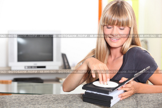 Female teenager choosing DVD. Стоковое фото, агентство Ingram Publishing / Фотобанк Лори