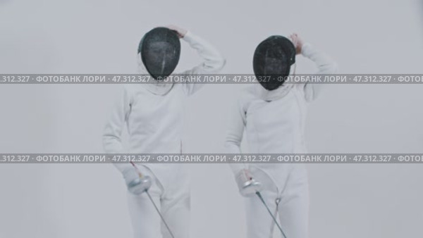 Fencing - two young women fencers in white suits putting on their protective helmets and stands in front of each other. Стоковое видео, видеограф Константин Шишкин / Фотобанк Лори