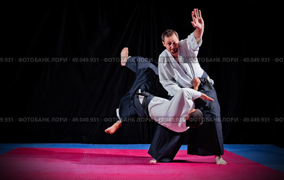 Fight between two aikido fighters on black. Стоковое фото, агентство Ingram Publishing / Фотобанк Лори