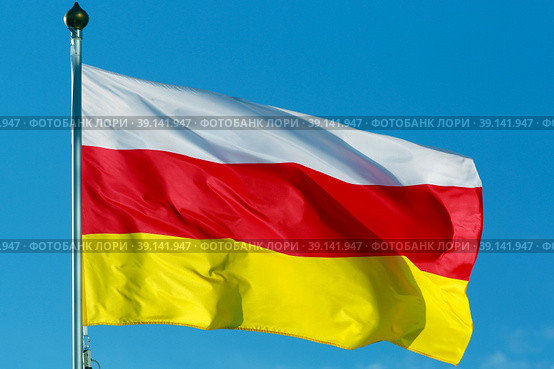 Флаг непризнанной самопровозглашённой республики Южная Осетия (2022 год). Редакционное фото, фотограф Александр Тарасенков / Фотобанк Лори