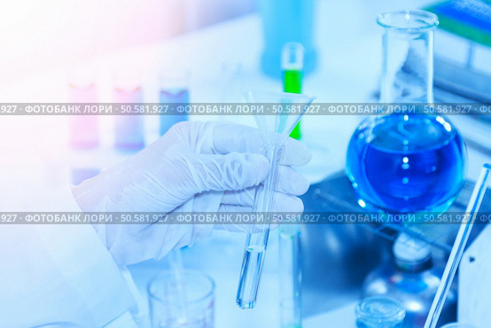 Flask in scientist hand with test tubes for analysis. Стоковое фото, агентство Ingram Publishing / Фотобанк Лори