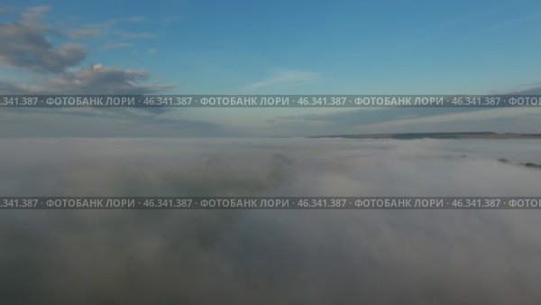 Flight from above over dense fog at dawn. Стоковое видео, видеограф Михаил Коханчиков / Фотобанк Лори