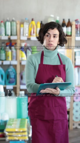 Focused marketer checking stock and making notes at household goods shop. Стоковое видео, видеограф Яков Филимонов / Фотобанк Лори