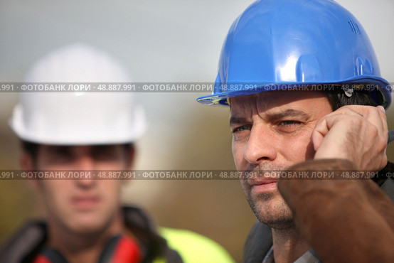 Foreman communicating via radio. Стоковое фото, агентство Ingram Publishing / Фотобанк Лори