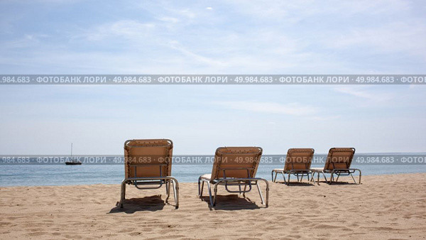 Four beach chairs on the beach. Spain, Barcelona beach. Four beach chairs on the beach. Стоковое фото, агентство Ingram Publishing / Фотобанк Лори