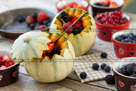 French melons filled with berries: blueberries, strawberries, blackberries and redcurrants.. French Melons Filled With Berries. Стоковое фото, агентство Ingram Publishing / Фотобанк Лори