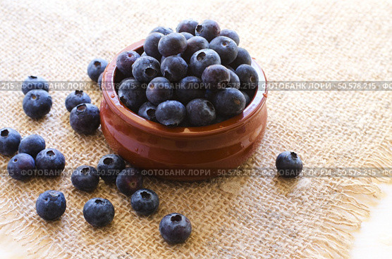Fresh blueberries in clay bowl on sacking  background. Стоковое фото, агентство Ingram Publishing / Фотобанк Лори