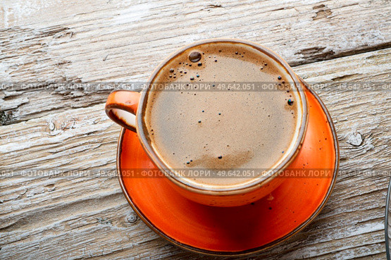 fresh boiled coffee served in beautiful orange cup around old style wooden background . close up. flat lay . Стоковое фото, агентство Ingram Publishing / Фотобанк Лори