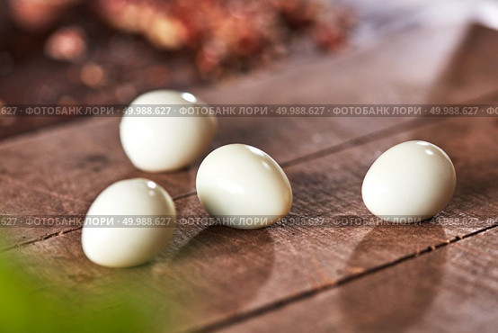 Fresh boiled peeled quail eggs on an old wooden background with reflection of shadows. Healthy food. Cooking peeled quail eggs presented on an old wooden table. Ingredient for Healthy Salad. Стоковое фото, агентство Ingram Publishing / Фотобанк Лори