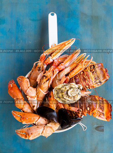 Fresh seafood catch of lobsters, crabs, and langostines on blue background. Fresh seafood on blue background. Стоковое фото, агентство Ingram Publishing / Фотобанк Лори