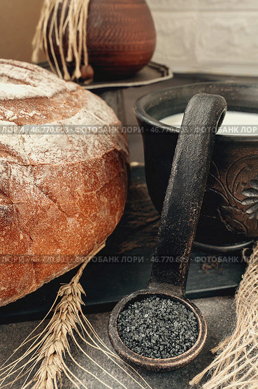 Freshly baked bread with a bowl of cream and a spoonful of rustic black volcanic salt. Стоковое фото, фотограф Оксана Медведева / Фотобанк Лори