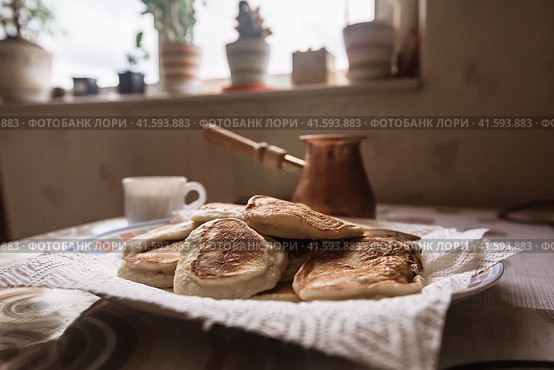 Freshly baked pancakes in plate on table. Tasty morning breakfast with hot flapjacks and coffee. homemade delicious fried pancakes. Selective focus. Стоковое фото, фотограф Константин Григорьев / Фотобанк Лори