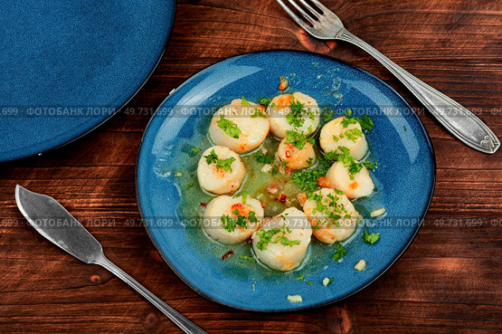 Fried delicious scallops with green on a plate. Seared scallops on a plate. Стоковое фото, агентство Ingram Publishing / Фотобанк Лори
