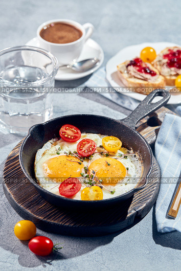 Fried eggs in cast-iron skillets. Sunny morning breakfast concept. Стоковое фото, фотограф Ирина Буракова / Фотобанк Лори