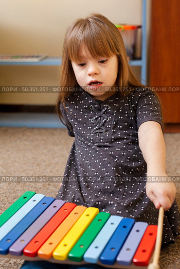 front view girl with down syndrome playing with xylophone. Стоковое фото, агентство Ingram Publishing / Фотобанк Лори