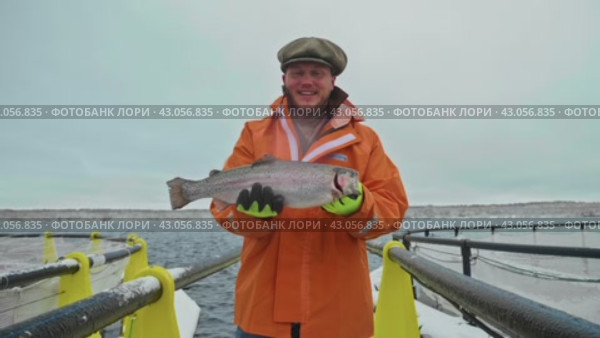 Frosty Harvest: Proud Fisherman with Fresh Catch at Aquaculture Farm. Стоковое видео, видеограф Даниил Хабаров / Фотобанк Лори