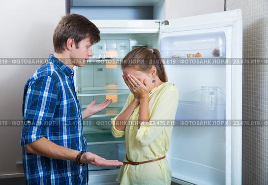 Frustraited starving female and man near fridge without any food. Стоковое фото, фотограф Яков Филимонов / Фотобанк Лори