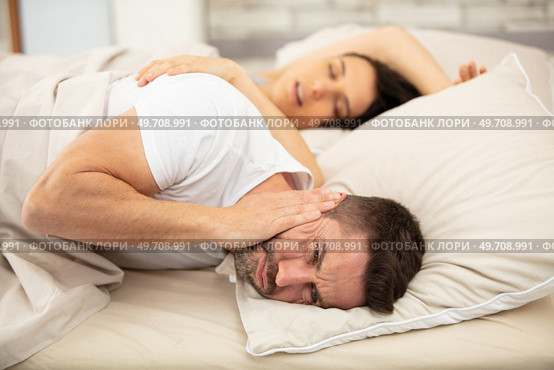 frustrated man cannot fall asleep wife snoring. Стоковое фото, агентство Ingram Publishing / Фотобанк Лори
