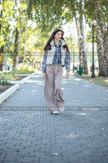 Full-length portrait of a young beautiful girl in a checkered shirt and beige pants. Стоковое фото, фотограф Андрей Аркуша / Фотобанк Лори