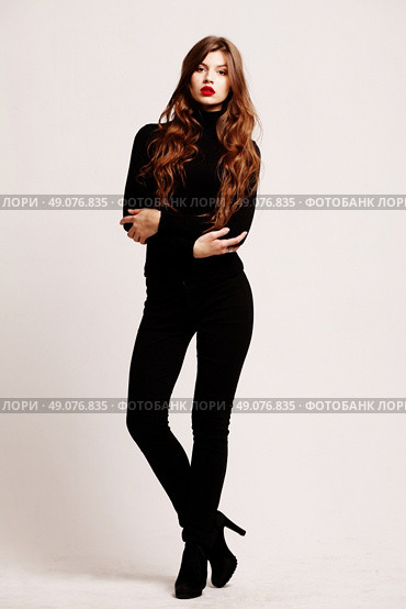 Full-length portrait young elegant woman in a black turtleneck and black skinny jeans. Fashion studio shot. Fashion model. Стоковое фото, агентство Ingram Publishing / Фотобанк Лори