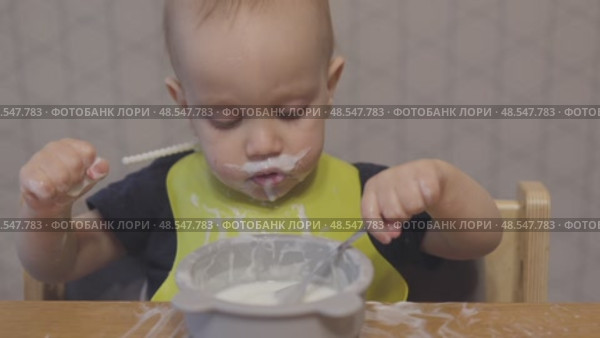 funny baby toddler learning to eat with spoon, child learn eating use teaspoon. Стоковое видео, видеограф Olesia Kondrateva / Фотобанк Лори