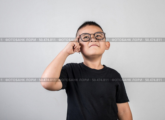 Funny Genius boy Thinking in studio shot. Стоковое фото, агентство Ingram Publishing / Фотобанк Лори
