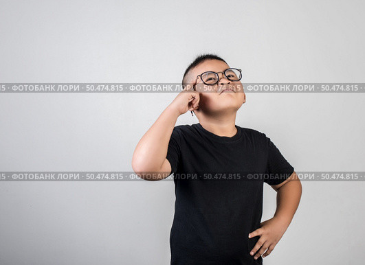 Funny Genius boy Thinking in studio shot. Стоковое фото, агентство Ingram Publishing / Фотобанк Лори