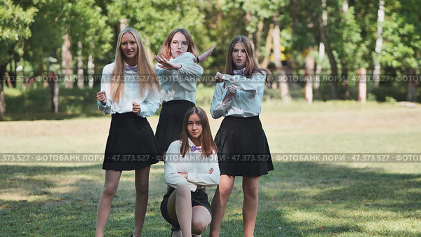 Funny schoolgirls posing and goofing around in a meadow. Стоковое фото, фотограф Mikhail Davidovich / Фотобанк Лори