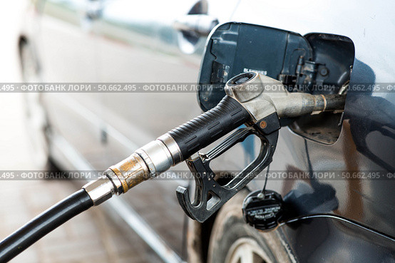 Gas station. Refueling a car with gasoline. Fuel dispenser in the car's fuel tank at a gas station. Rising fuel prices worldwide. Стоковое фото, фотограф Photojuli / Фотобанк Лори