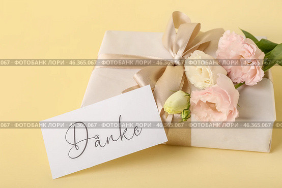 Gift box, card with text DANKE and eustoma flowers on color background, closeup. Стоковое фото, фотограф Pixel_shot / Фотобанк Лори