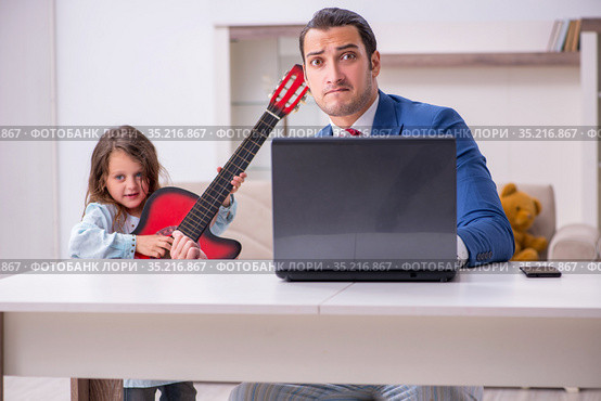 Girl bothering young father during working from house in pandemi. Стоковое фото, фотограф Elnur / Фотобанк Лори