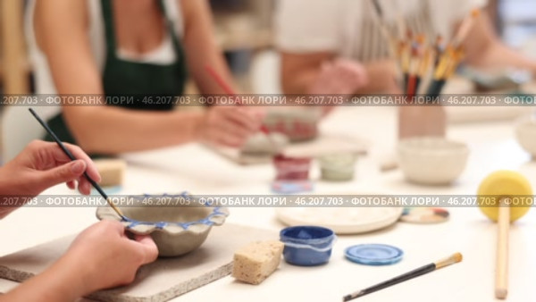 Girl hands paints bowl of clay during master class, close up. Стоковое видео, видеограф Яков Филимонов / Фотобанк Лори