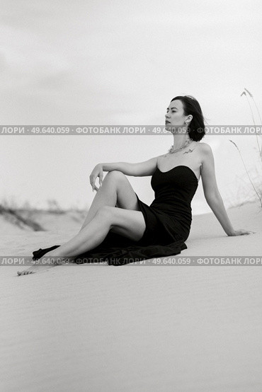 girl in a black long dress in a sandy desert under a blue sky. Стоковое фото, агентство Ingram Publishing / Фотобанк Лори