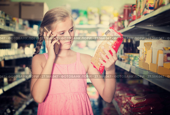 Girl is advised by phone what pasta she should buy. Стоковое фото, фотограф Яков Филимонов / Фотобанк Лори