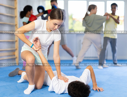 Girl practicing painful armlock in sparring with boy at self defence training. Стоковое фото, фотограф Яков Филимонов / Фотобанк Лори