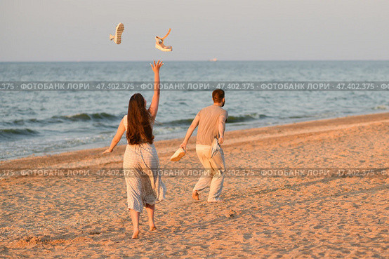 Girl throws sandals up in the ocean. Beginning of vacation, honeymoon. Стоковое фото, фотограф Irina Kuchugurina/Gaudy / Фотобанк Лори