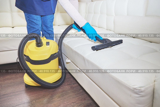 Girl vacuuming sofa indoors industrial vacuum cleaner. Стоковое фото, фотограф Стас Пересыпкин / Фотобанк Лори