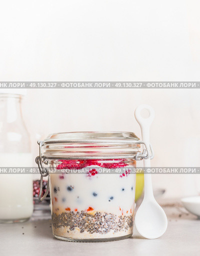 Glass jar with Healthy breakfast : oatmeal , Chia seeds, Goji berries, fresh berries and yogurt, front view. Стоковое фото, агентство Ingram Publishing / Фотобанк Лори