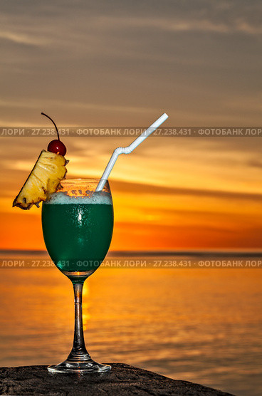 Glass of drink is on a beach table. Стоковое фото, фотограф М / Фотобанк Лори