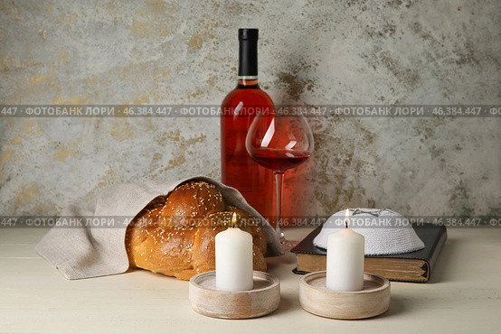 Glowing candles with traditional challah bread, wine, Torah and Jewish cap on grunge background. Shabbat Shalom. Стоковое фото, фотограф Pixel_shot / Фотобанк Лори