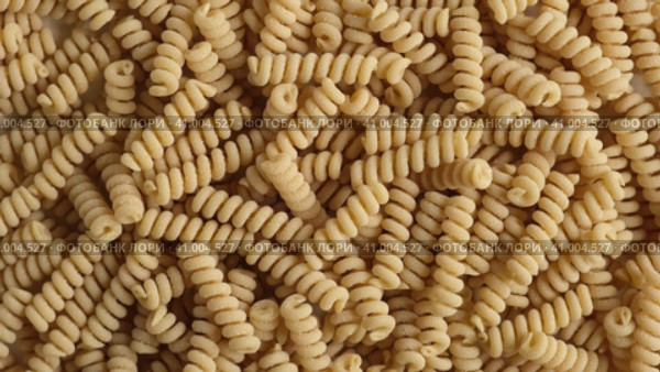 Gluten Free Cornmeal Pasta Wallpaper. Spiral Raw Macaroni from Corn and Rice flour rotating on Turntable. Close Up Top View. Uncooked Pasta Spinning. Full Frame. Food Background. Fusilli Bucati Corti. Стоковое видео, видеограф Марина Демидюк / Фотобанк Лори