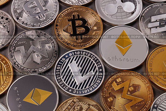 Gold and silver coins, LTC, ETH, BTC, XMR, XRP. A pattern from different coins of virtual currency on a dark background. Cryptocurrency and blockchain concept. Top view. Many different coins of crypto currency on a dark background. Business and technology concept. Top view. Стоковое фото, агентство Ingram Publishing / Фотобанк Лори