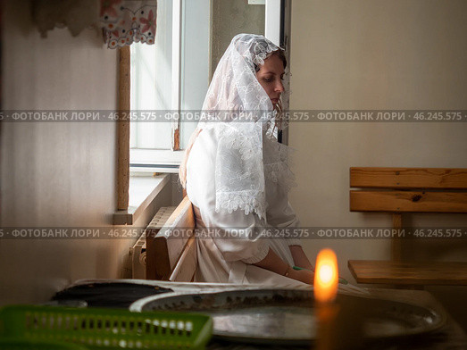 Gomel, Belarus - 02 Sept 2023: Beautiful bride in white robe and veil sitting near window in church. Редакционное фото, фотограф Дмитрий Нечаев / Фотобанк Лори