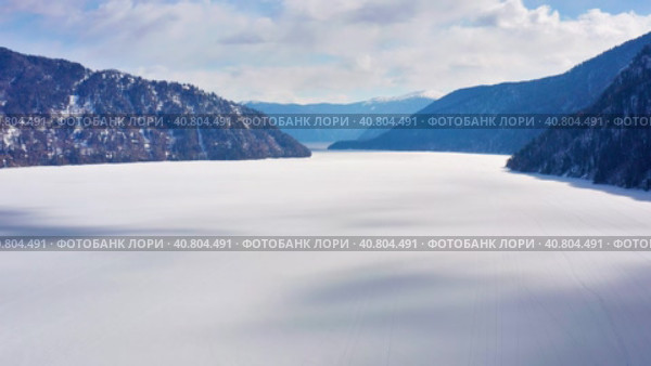 Горный Алтай зимой: Телецкое озеро. Вид с воздуха. Altai mountains in winter: Teletskoye lake. Aerial view. Стоковое видео, видеограф Евгений Романов / Фотобанк Лори
