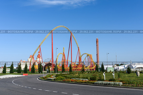 Город Сочи, Краснодарский край, Адлер солнечным днём. Улица  Чемпионов с видом на аттракцион "Змей Горыныч" в парке аттракционов «Сочи-Парк» на фоне неба (2018 год). Редакционное фото, фотограф Игорь Низов / Фотобанк Лори