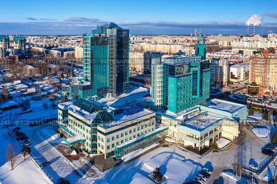 Город Сургут зимой. Здания Газпром трансгаз Сургут и Газпромбанка. Вид с воздуха. Surgut city in winter. Gazprom Transgaz Surgut and Gazprombank buildings. Aerial view. (2022 год). Стоковое фото, фотограф Евгений Романов / Фотобанк Лори