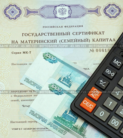 Государственный сертификат материнский (семейный) капитал, калькулятор и российский деньги (2024 год). Редакционное фото, фотограф Цибаев Алексей / Фотобанк Лори