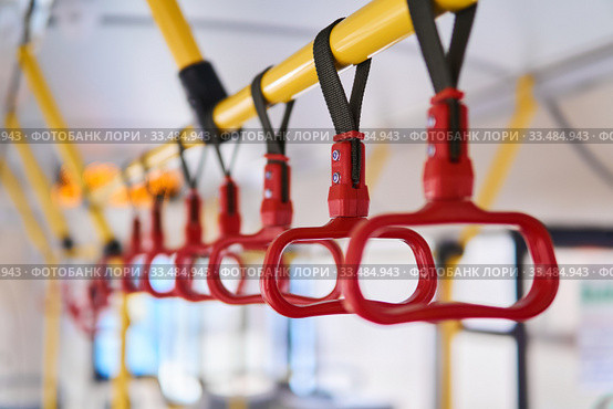 Grab handles in the passenger compartment of the bus on a blurred background. Стоковое фото, фотограф Евгений Харитонов / Фотобанк Лори